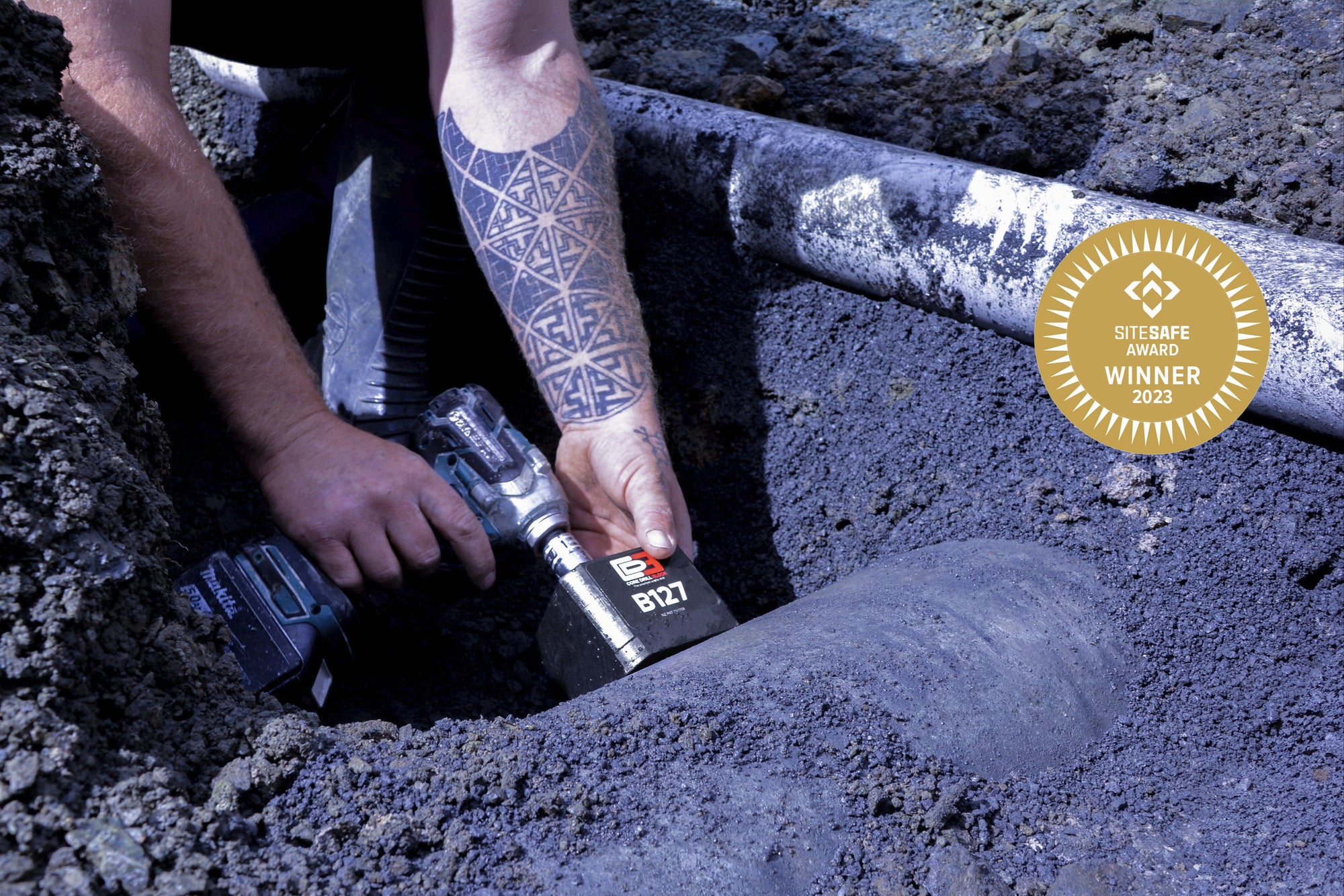 Person using a core drill block on a concrete pipe
